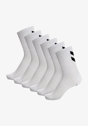 Calze di cotone bianche con polsini a costine, caratterizzate da triangoli neri. Sei paia disposti in fila, che evidenziano il tessuto leggero e il design.