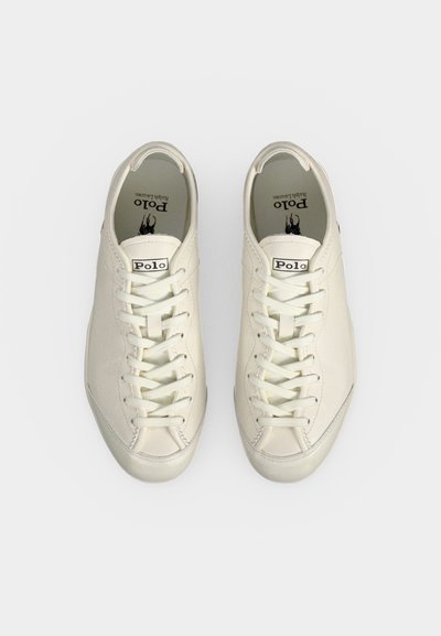 Ζευγάρι λευκά sneakers Polo Ralph Lauren με κορδόνια, βλέποντας από πάνω σε απλό φόντο.