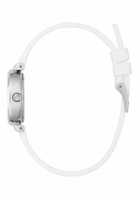 Ceas argintiu cu un brățară din silicon alb, prezentând un cadran rotund neted și un design minimalist, văzut din lateral.