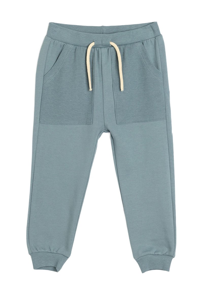 Pantalones de chándal azul claro con bolsillos frontales acanalados, cintura elástica, cordón crema y puños ajustados. Fabricados en suave material de algodón.