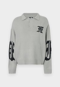 Ανοιχτό γκρι πλεκτό πουλόβερ με ριμπ τελείωμα και γιακά. Διαθέτει μαύρες λεπτομέρειες με λογότυπο στο στήθος και στα μανίκια. Απαλή υφή.