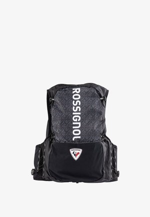 Mochila negra con una parte superior estampada, que presenta el logo "ROSSIGNOL" en blanco. Incluye bolsillos laterales y un parche de logo triangular en la parte frontal.