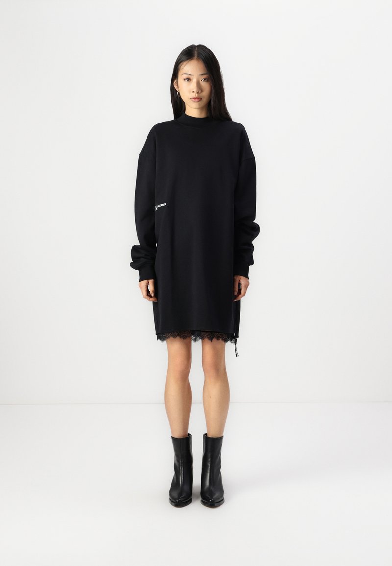 Róchia neagra din molton cu maneci lungi, detaliu din dantela pe tiv si decolteu inalt. Are un logo alb mic pe lateral si o croiala lejera.