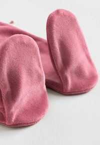 Zapatillas forradas de felpa rosa con grandes orejas redondeadas, con una textura suave y un acabado liso. La base tiene un borde rosa ligeramente más oscuro.