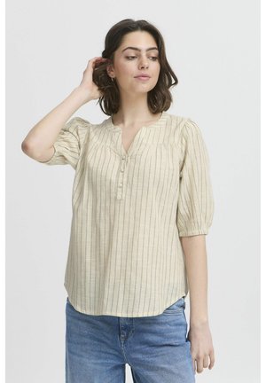 Beige striped blouse in lightweight fabric with a V-neck, short puff sleeves, and a button closure, paired with blue jeans.