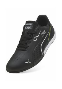 Czarne sportowe buty z gładką, syntetyczną cholewką z perforowanymi detalami, sznurowadłami oraz kontrastującymi białymi i zielonymi akcentami.