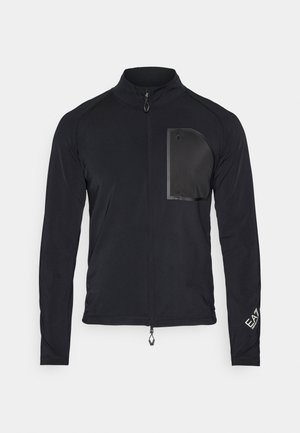 Must matte mustsleevesiga jope, mis on valmistatud siledast kangast. Omab lukuga rinna taskut, püsti krae ning elastseid mansette. Peen logo detail.