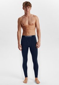 Marine termisk leggings med en strækpasform, der har et brandet livbånd. Glat tekstur, fuldlængde design og en klassisk snit for komfort.