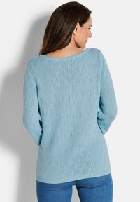 Hellblau gestrickter Pullover mit Rautenmuster, langen Ärmeln und weitem Halsausschnitt. Verfügt über gerippte Bündchen und Saum für zusätzliche Textur.