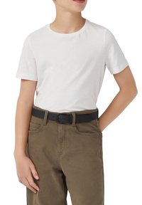 Wit T-shirt met korte mouwen gecombineerd met olijfgroene broek; zwarte riem met een eenvoudige gesp, eenvoudige textuur en reguliere pasvorm.