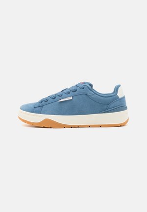 Baskets en daim bleu avec un col rembourré, des accents blancs et une semelle en caoutchouc naturel. Comprend un design à lacets et un logo sur le côté.