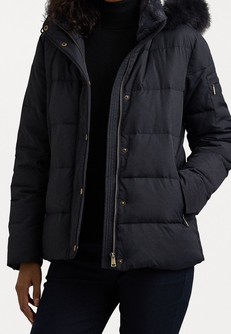 Černá péřová bunda s kapucí podšitou umělou kožešinou, se zapínáním na patentky a zip a prošívaným designem. Obsahuje zlaté akcenty a boční kapsy.
