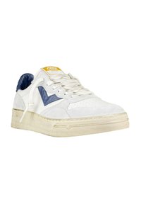 Sneaker bianca con accenti blu navy, materiali in suede e pelle, punta perforata, suola spessa e testurizzata, e una etichetta gialla con logo sulla linguetta.