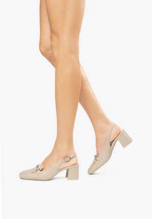 Scarpe slingback beige con punta quadrata, tacco a blocco e dettaglio decorativo in metallo. Texture in pelle liscia e design con retro aperto.