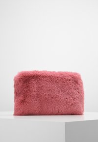Pochette rose en fausse fourrure de forme rectangulaire, texture douce, avec un bord supérieur légèrement incurvé, adaptée à un usage décontracté ou formel.