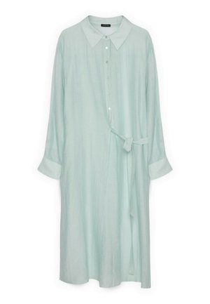 Lyseblå skjortekjole med lange ærmer, knapper foran, spids krave, manchetærmer og et bånd, der er bundet i taljen på højre side.