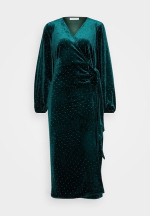 Smaragdovo zelené sametové zavinovacie šaty s dlhými rukávmi, výstrihom do V, bočným viazaním a rozptýlenými striebornými bodkami. Hladká textúra.