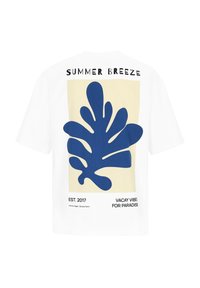 Weißes T-Shirt mit großem blauem abstraktem Blättergrafik, dem Text "SUMMER BREEZE" darüber und "EST. 2017" sowie urlaubsbezogenem Text darunter.