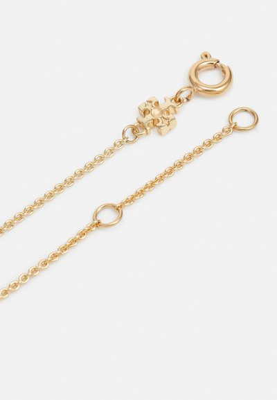 Zelta ķēdes kaklarota ar omāro skavu, kurai ir ģeometrisks akcents un apaļi gredzeni visā garumā. Gluda tekstūra ar pulētu apdari.