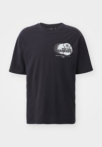 Black cotton t-shirt with short sleeves. Features a printed New York Yankees logo and graphic on the front in white and gray.