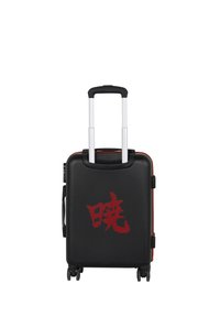 Maleta rígida negra con carácter kanji japonés rojo, asa telescópica extendida, cuatro ruedas y asa lateral.