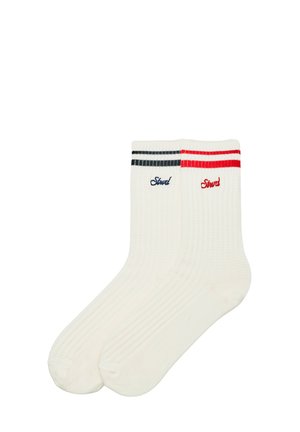 Paire de chaussettes blanches côtelées arrive à la cheville, l'une avec des rayures noires et broderies, l'autre avec des rayures rouges et broderies près du haut.