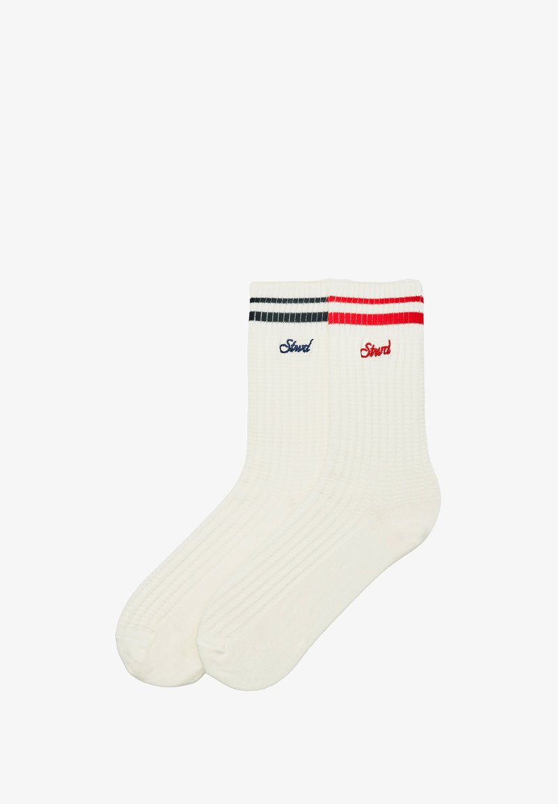 Paire de chaussettes blanches côtelées arrive à la cheville, l'une avec des rayures noires et broderies, l'autre avec des rayures rouges et broderies près du haut.