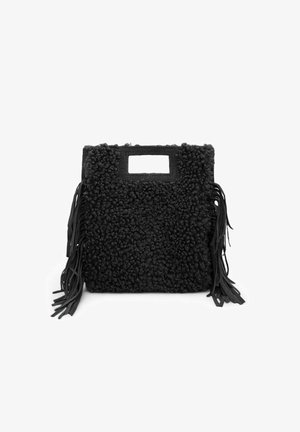 Sac noir avec un extérieur texturé et duveteux, doté de franges latérales, d'une poignée découpée rectangulaire et d'une forme carrée.