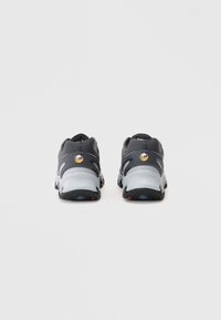 Par crnih i sivih Nike Air Max tenisica viđena sa stražnje strane na jednostavnoj bijeloj pozadini.