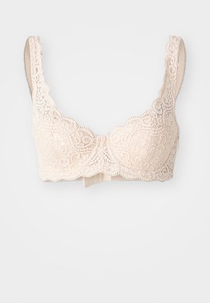 Lace bralette in zacht beige met decoratieve scalloped randen, voorzien van verstelbare bandjes en een gladde onderband voor ondersteuning.