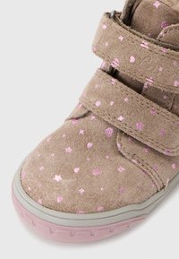 Shoe s suchým zipem v světle hnědé semišové kůži se pink hvězdami a srdíčky. Obsahuje gumovou podešev se vzorovaným okrajem a polstrovaným límcem.
