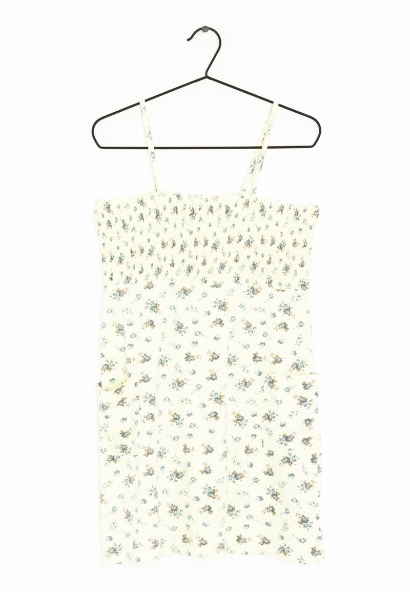 Robe à motif floral en crème avec corsage froncé et bretelles fines. Présente de petites poches de chaque côté. Tissu léger, coupe décontractée.