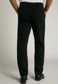 Schwarze Hose mit geradem Schnitt, elastischem Bund und Gesäßtasche; aus weichem Stoff gefertigt und mit einer glatten Textur.