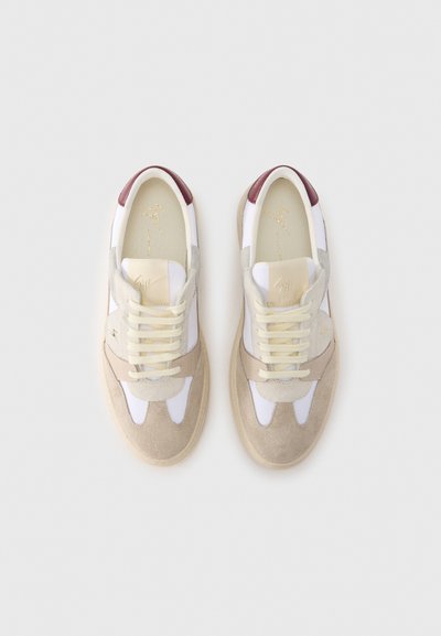 Bėgimo bateliai smėlio spalvos ir balti, pagaminti iš zomšos ir tinklinio audinio. Yra šviesiai pilkų ir vyno spalvos akcentų, plokščios raištelės ir tekstūruota guminė padas.