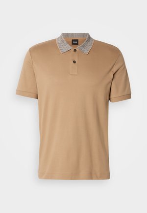 Brah polo majica z vzorčasto ovratnikom, dvema gumboma na zapenjanju in kratkimi rokavi. Narejena iz gladkega bombažnega materiala.