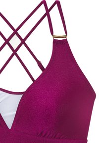 Mauve bikini top z vkrižanimi trakovi in zlatim okrasnim členom. Ima metalni videz in mehko podlogo v kontrastni beli barvi.