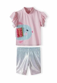 Chemise rose à manches courtes avec des manches volantes, ornée d'un motif de poisson bleu avec des accents texturés, associée à un short ombragé brillant.