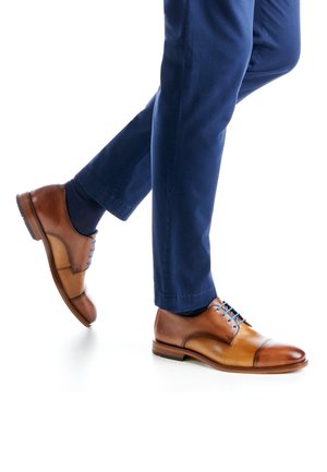 Braune Lederkleidschuhe mit einer Kappe, blauen Schnürsenkeln und einer glatten Textur, kombiniert mit marineblauen Hosen.