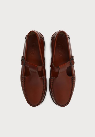 Paire de sandales en cuir marron à bout fermé avec brides latérales à boucle et détails cousus, vues de dessus sur un fond uni.