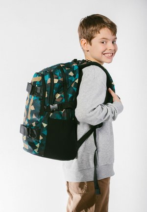 Lo zaino presenta un motivo geometrico in teal, nero e beige, con spallacci imbottiti e scomparti multipli per lo stoccaggio.