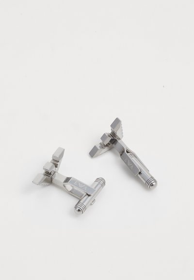 Silver metal cufflinks with geometric shapes, featuring a textured surface and engraved detailing, arranged on a plain white background.