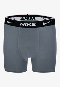 Pelēki kokvilnas bokseru apakšveļa ar melnu elastīgu jostu, uz kuras priekšpuses un iekšējā odere ir drukāts balts "NIKE" logo.