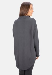 Dark grey, long-sleeve button-up shirt in textured fabric, featuring a loose fit and rounded hem, with a classic collar and cuffs.