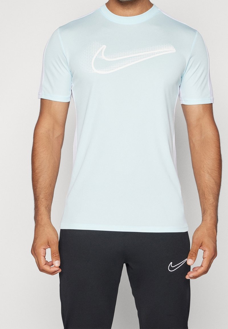 Light blue short-sleeve athletic shirt with a white Nike swoosh logo. Designed with a smooth, stretchy fabric and a rounded neckline.