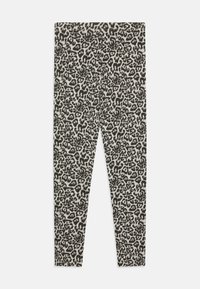 Leggings en imprimé léopard en tissu jersey doux, avec un fond neutre et des taches noires et gris foncé, coupe slim et taille élastique.