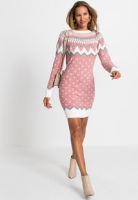Abito maglione rosa con motivi geometrici bianchi e grigi, maniche lunghe, dettagli a coste e silhouette aderente.