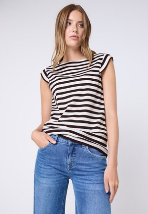 Gestreepte t-shirt in crème en donkerbruin, met een ronde hals en korte mouwen, gecombineerd met lichtblauwe denim jeans.