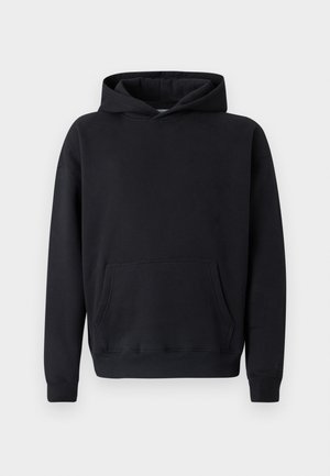 Melns džemperis ar kapuci, izgatavots no mīksta auduma. Ir priekšējā kabata, kapuce ar aukliņu un ribota apmale pie piedurknēm. Vienkāršs dizains bez redzamām rakstām vai akcentiem.