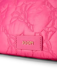 Bolsa de nylon acolchada en color rosa con un sutil patrón floral. Presenta una etiqueta texturizada con "JOOP!" en relieve dorado. Acabado suave, diseño acolchado.