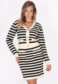 Vestido de cárdigan a rayas en negro y crema con forma ajustada, textura acanalada y detalles de botones dorados en el frontal y los bolsillos.